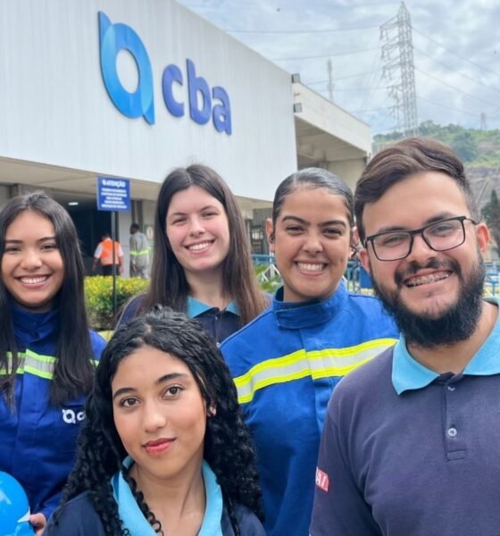 Group of five volunteers in blue uniforms pose outside a building with a CBA sign smiling for the photo during a vaccination campaign