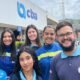 Group of five volunteers in blue uniforms pose outside a building with a CBA sign smiling for the photo during a vaccination campaign