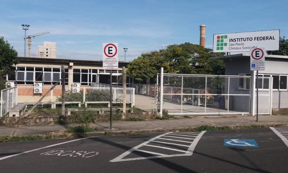 Entrance to Instituto Federal São Paulo campus Sorocaba with a gated fence and a handicap parking space marked on the pavement fringing a blue and white symbol (wheelchair).