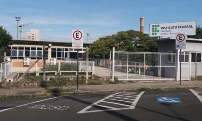 Entrance to Instituto Federal São Paulo campus Sorocaba with a gated fence and a handicap parking space marked on the pavement fringing a blue and white symbol wheelchair