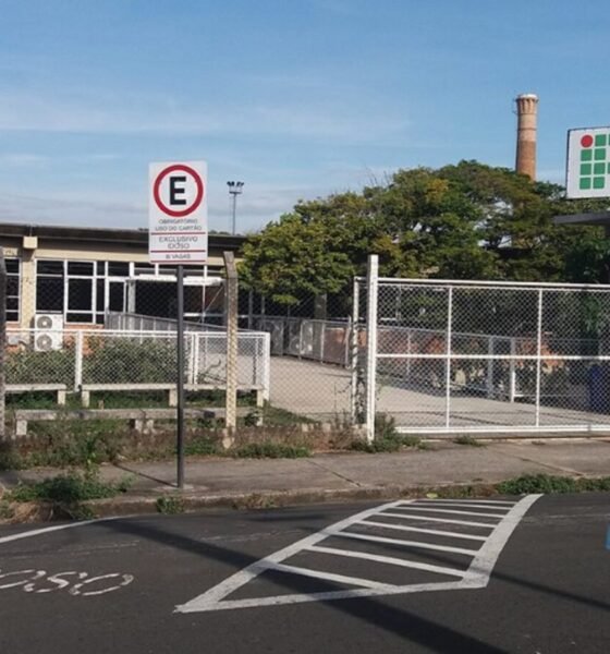 Entrance to Instituto Federal São Paulo campus Sorocaba with a gated fence and a handicap parking space marked on the pavement fringing a blue and white symbol wheelchair