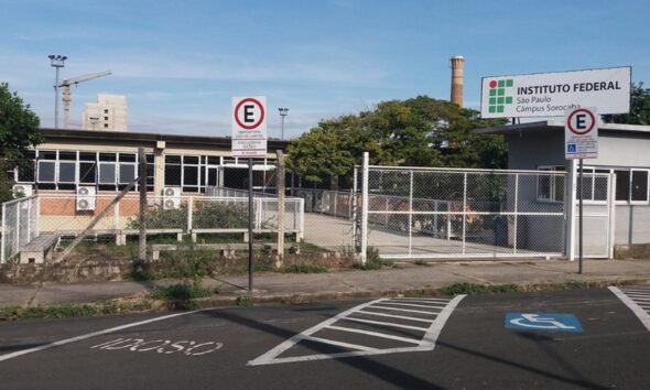 Entrance to Instituto Federal São Paulo campus Sorocaba with a gated fence and a handicap parking space marked on the pavement fringing a blue and white symbol wheelchair