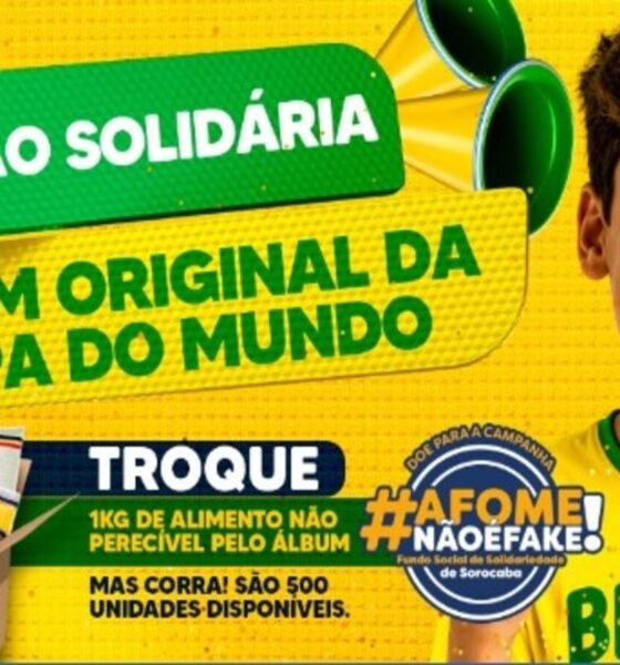 Jovem brasileiro com camiseta amarela e rosto pintado vibra ao lado de uma caixa de alimentos para uma ação solidária da Copa do Mundo