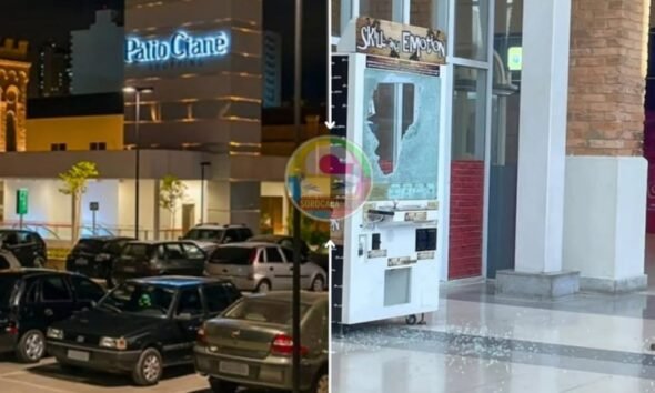 Night scene of a parking lot filled with cars with a lit building sign Patio Crane in the background and on the right a storefront with a shattered glass window and a vending machine inside the display area