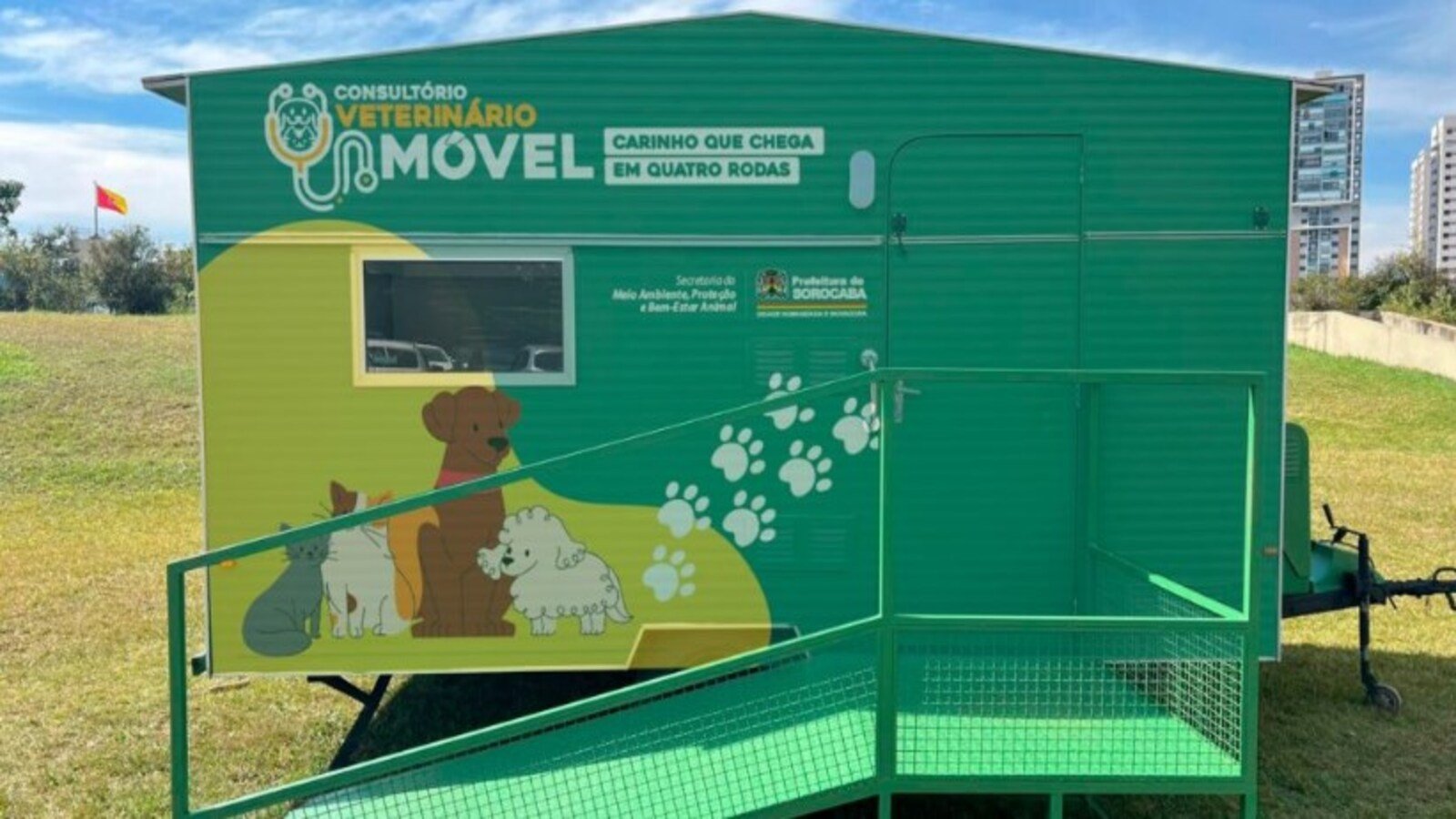 Mobile veterinary clinic trailer in green with dog artwork and white paw prints slogan reads Consultório Veterinário Móvel and Carinho que chega em quatro rodas Brazilian veterinary service