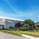 Modern glass front corporate building with ChemyUnion sign surrounded by palm trees on a sunny day