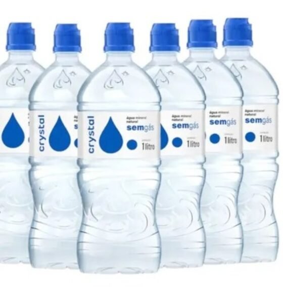 Six  liter plastic water bottles with blue caps arranged in a row label shows a blue droplet and crystal