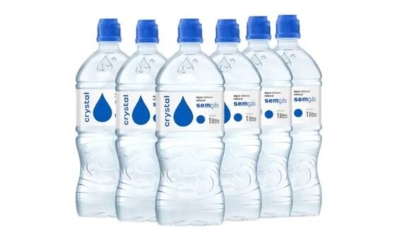 Six  liter plastic water bottles with blue caps arranged in a row label shows a blue droplet and crystal