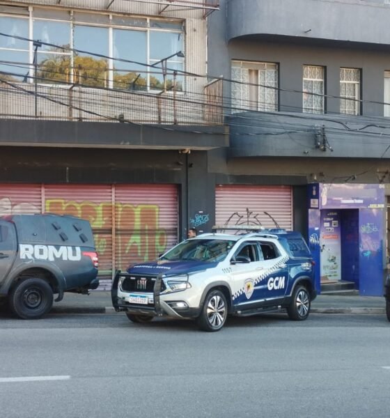 Three police vehicles parked along a city street in front of graffiti covered storefronts left a gray ROMU pickup center a white and blue GCM SUV right a dark ROMU SUV