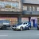 Three police vehicles parked along a city street in front of graffiti covered storefronts left a gray ROMU pickup center a white and blue GCM SUV right a dark ROMU SUV