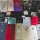 Cart overflowing with dozens of smartphones backs facing up in various colors and models likely second hand devices for sale