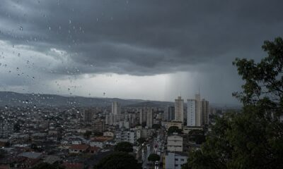 City skyline under dark storm clouds raindrops on a window fill the foreground