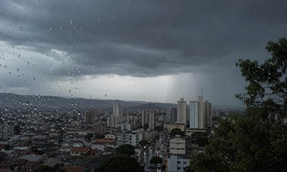 City skyline under dark storm clouds raindrops on a window fill the foreground
