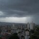City skyline under dark storm clouds raindrops on a window fill the foreground