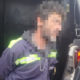 Man wearing a dark jacket with neon reflective stripes leaning into an open van a hand near the tailgate edge