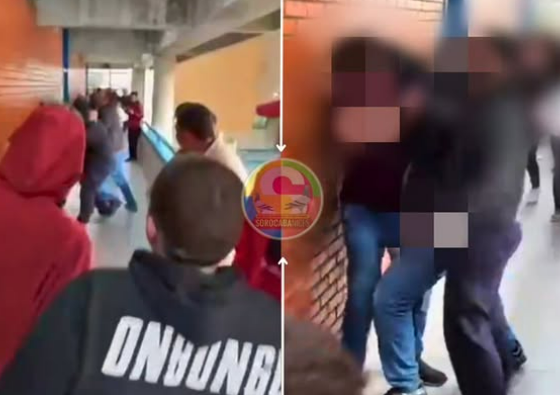 Crowd of students in a school hallway some facing a brick wall right side shows blurred faces to protect privacy