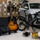 Assorted consumer goods on a table in a warehouse iPhone box PS guitar Canyon bike sneakers watch and perfume