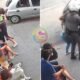 Split screen street scene left side shows a confrontation with a man restraining another person while bystanders sit along the curb right side shows a police officer escorting someone toward a parked car with a blurred group nearby