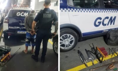 Uniformed officer escorts a handcuffed man toward a GCM police van in a parking area with equipment nearby