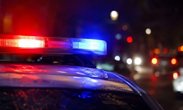 Police car with red and blue emergency lights flashing at night
