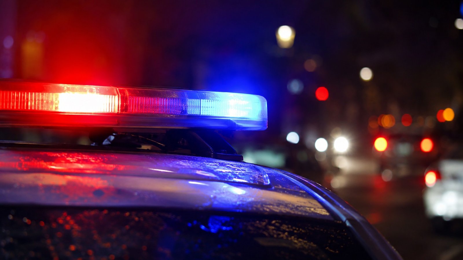 Police car with red and blue emergency lights flashing at night
