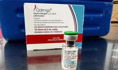 Box of Qdenga dengue vaccine and a small vial on a reflective surface with labeling showing dose information  doses  mL
