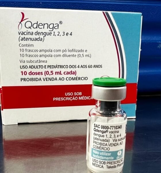 Box of Qdenga dengue vaccine and a small vial on a reflective surface with labeling showing dose information  doses  mL