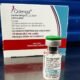Box of Qdenga dengue vaccine and a small vial on a reflective surface with labeling showing dose information  doses  mL