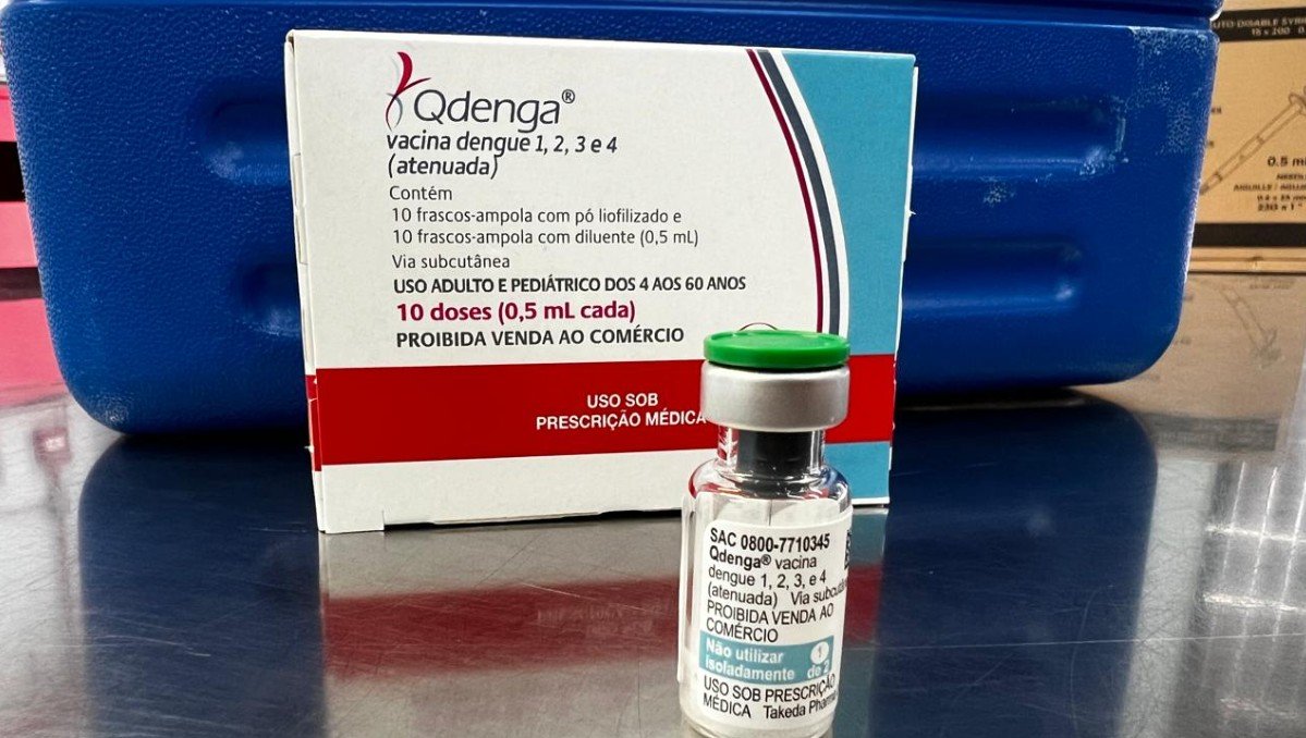 Box of Qdenga dengue vaccine and a small vial on a reflective surface with labeling showing dose information  doses  mL