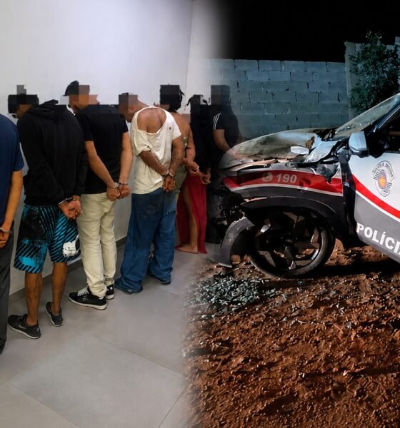 Police lineup officers in uniform with detainees handcuffed against a wall inside a station