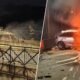 Two views of a car crash at night on the left a burnt out car on a bridge with firefighters nearby on the right a car engulfed in flames with debris around